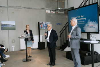 Zwei Männder stehen auf der Bühne und sprechen